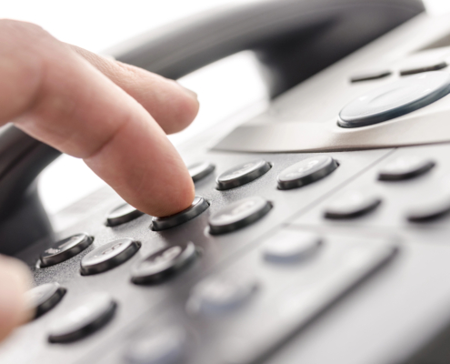 Close-up of a hand dialing a business phone for professional communication.