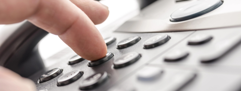 Close-up of a hand dialing a business phone for professional communication.